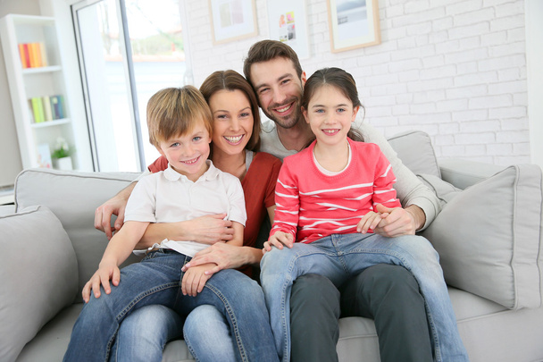Family sitting on sofa - Фото, изображение