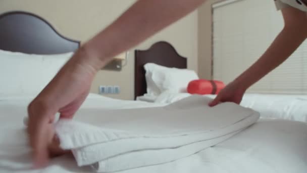 Aasialainen sisäkkö laittaa valkoinen tuore pellava sängyssä asiakkaiden hotellihuoneessa - Materiaali, video