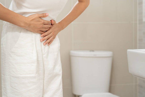 Constipation and diarrhea in bathroom. Hurt woman touch belly  stomach ache painful. colon inflammation problem, toxic food, abdominal pain, abdomen, constipated in toilet, stomachache, Hygiene - Photo, image