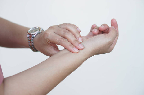 Крупним планом жіноча рука перевіряє пульс на руці, порівнює пульсовий ритм з годинником. Концепція, медична допомога. Самоперевірка пульсу серця на зап'ясті. - Фото, зображення