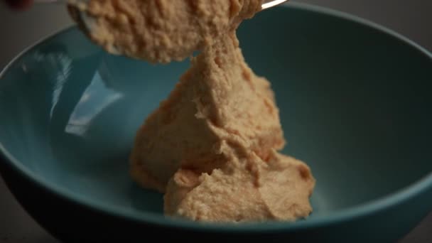 Un video accattivante con un primo piano delle mani di una donna che presenta splendidamente l'hummus in una ciotola blu, ideale per il cibo e il contenuto di cucina - Filmati, video