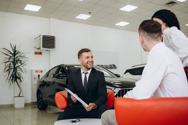 Couple buys a car in a car dealership. High quality photo - Photo, Image
