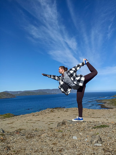 Una joven haciendo yoga asana llamada pose bailarina en la naturaleza salvaje - Foto, imagen