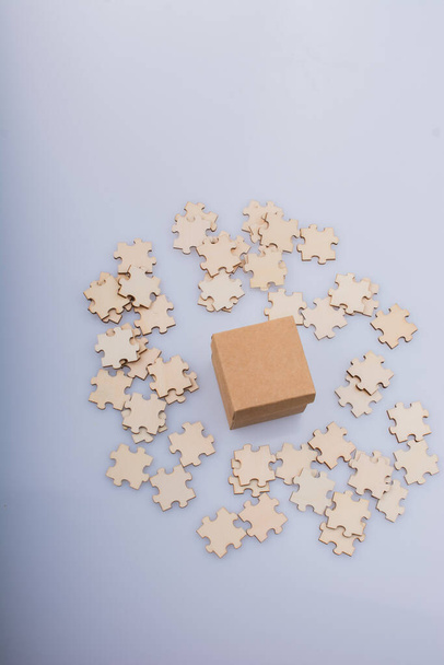 Pieces of jigsaw puzzle around box as problem solution business concept - Photo, Image