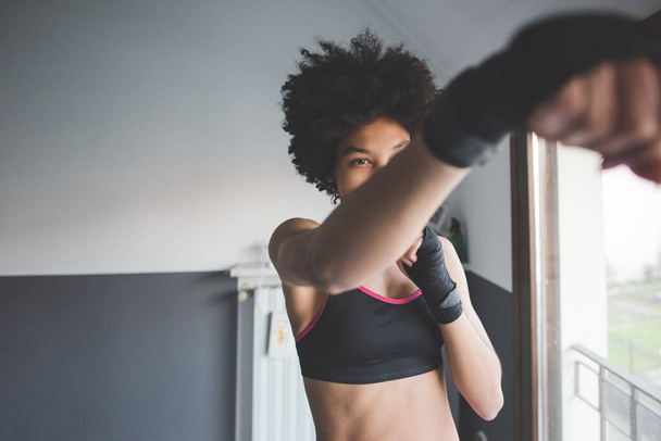 fiatal többnemzetiségű nő beltéri edzés box otthon  - Fotó, kép