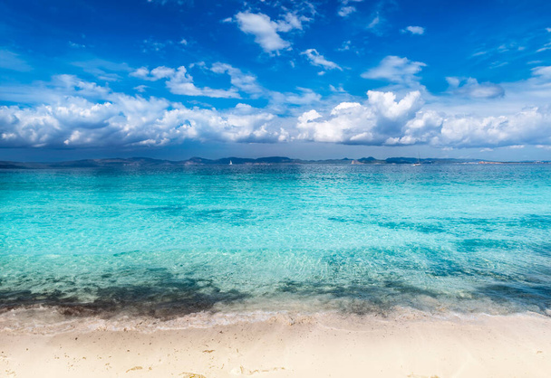 Aurinkosuukko rantaviiva ulottuu Formenteralle ja vangitsee saaren koskemattoman kauneuden. Kristallinkirkas vesi kiertää pehmeää hiekkaa vasten, tarjoten rauhallisen vetäytymisen tässä Välimeren paratiisissa - Valokuva, kuva