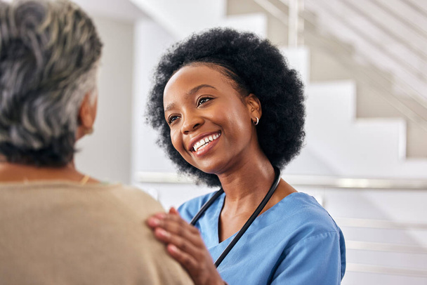 Black woman nurse, senior patient and help at retirement home with elderly care, support and counseling. People sitting together, healthcare and wellness with advice, kindness and respect with trust. - Photo, Image