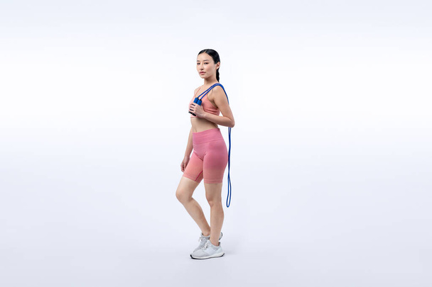 Jovem mulher asiática enérgica em sportswear com salto ou pulando roupão posando retrato em estúdio filmado em fundo isolado. Ferramenta de exercício cardiovascular e estilo de vida saudável. Vigoroso. - Foto, Imagem