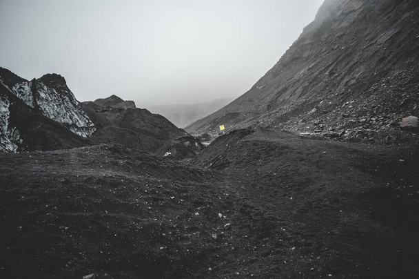 Пейзаж из серого песка рядом с ледником Solheimajokull в дождливую погоду, Исландия - Фото, изображение