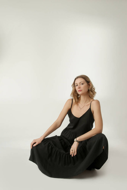  Σειρά φωτογραφιών στούντιο του νεαρού γυναικείου μοντέλου σε μαύρο λινό μακρύ φόρεμα καμισόλ. Casual και κομψό καλοκαιρινό ντύσιμο, τάση ανοιξιάτικης-καλοκαιρινής μόδας. - Φωτογραφία, εικόνα