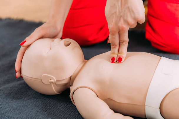 Learning infant CPR in a first aid training - cardiopulmonary resuscitation course using a baby dummy. - Photo, Image