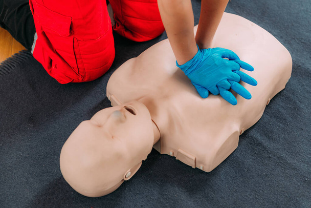  CPR-Schulung. Kompressionstechniken der Brust in einem Erste-Hilfe-Kurs mit einer Attrappe. - Foto, Bild