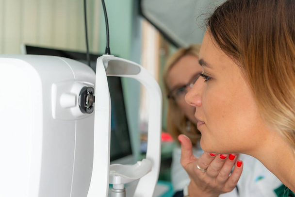 L'ophtalmologiste effectue une tomographie de cohérence optique précise, un outil essentiel pour une évaluation approfondie de la santé oculaire en milieu clinique.. - Photo, image