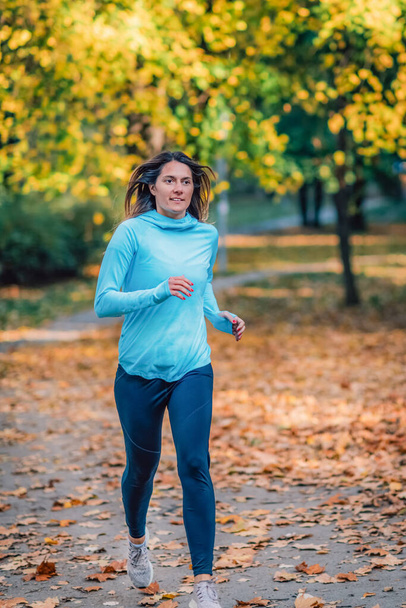 Žena běží ve veřejném parku na podzim. - Fotografie, Obrázek