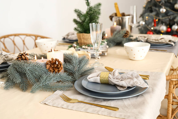 Χριστουγεννιάτικο τραπέζι με στεφάνια, αναμμένα κεριά και κουκουνάρια - Φωτογραφία, εικόνα
