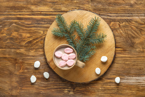 Šálek chutného vánočního kakaa s marshmallows a jedlovou větví na dřevěném pozadí - Fotografie, Obrázek