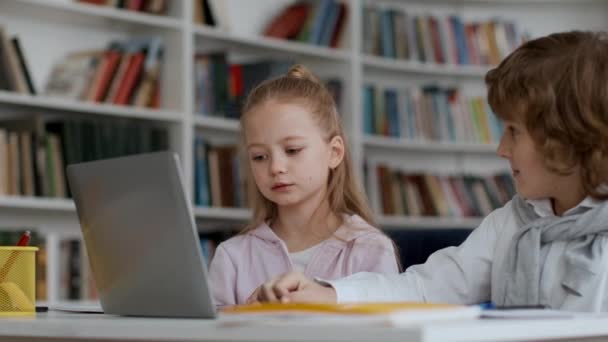 Moderní technologie pro koncepci vzdělávání. Pozorný chlapec a dívka řešení test na notebooku společně, výběr odpovědi a slaví úspěch, dává plácnutí si navzájem, sledování výstřel, zpomalený film - Záběry, video