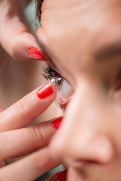 Expert oogarts demonstreert nauwkeurige soft contact lens inbrengen, waardoor de patiënt comfort en verbetering van het gezichtsvermogen. - Foto, afbeelding