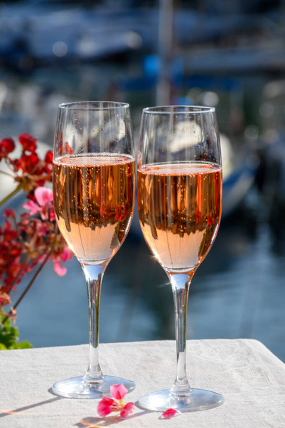 Letnia impreza, picie francuskiego brut rose szampana wina musującego w szklankach w porcie jachtowym Port Grimaud niedaleko Saint-Tropez, wakacje na Riwierze Francuskiej, Var, Francja - Zdjęcie, obraz