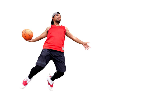ボールを保持し,クリッピングパスでジャンプするバスケットボール選手 - 写真・画像