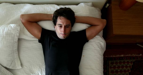 Man getting up from bed. Pensive person thinking about decision and taking decision - 写真・画像