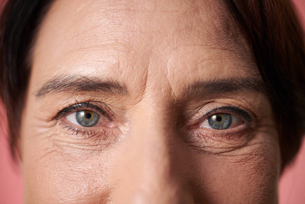 Глаза зрелой женщины с легким макияжем, смотрящей в камеру - Фото, изображение