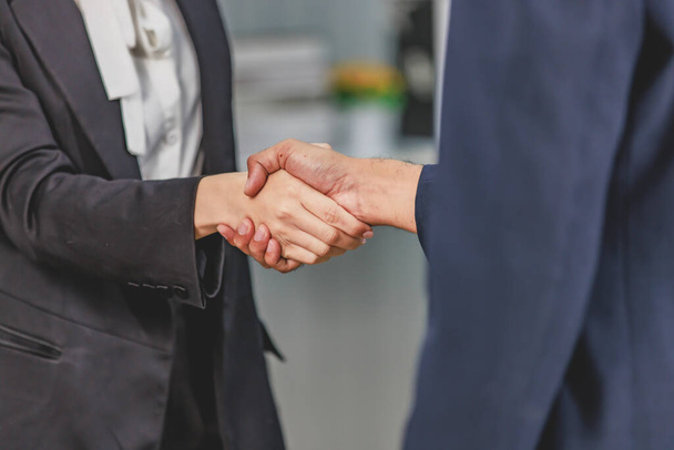 Closeup shot of Millennial unrecognizable unknown professional successful male businessman and female businesswoman in formal business suit shaking hands greeting deal done job agreement achievement. - Photo, Image