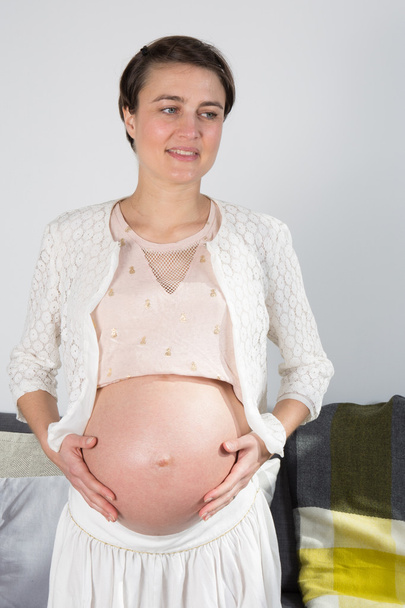 Беременная молодая женщина у себя дома
 - Фото, изображение