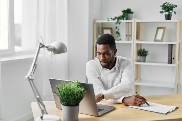 コピーマンビジネス アフリカのホームスペース 現代人 屋内コンピュータ アメリカ オンライン 座っているオフィス ラップトップ アメリカの教育学生 フリーランサー 起業家 企業テーブル - 写真・画像