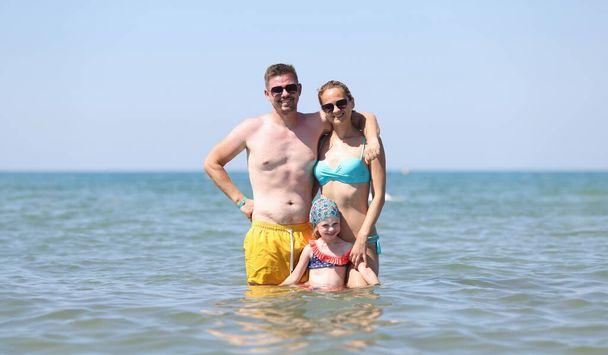 Happy family have fun on beautiful warm sunny beach in sea. Joyful family trips on summer to sea - Foto, imagen