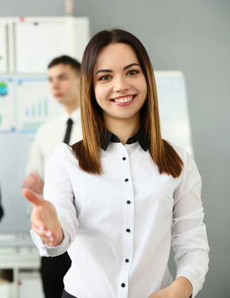 Smiling young business woman politely greets company office. Business consultant and team - Foto, Imagem