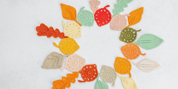 Grinalda de folhas de outono de malha. Handmade, conceito hobby outono em fundo de concreto de pedra leve, flat lay, fomat banner - Foto, Imagem