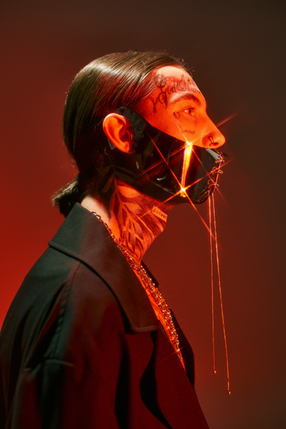 retrato de un hombre joven y elegante posando de perfil con chispas de luz en su máscara atada, moda - Foto, Imagen