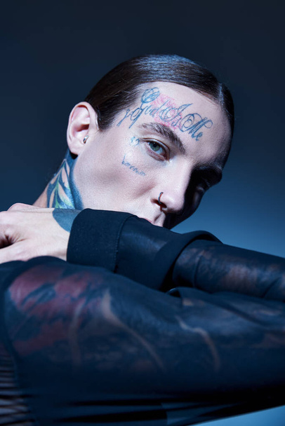 vertical shot of stylish sexy man in transparent shirt with tattoos looking at camera, fashion - 写真・画像
