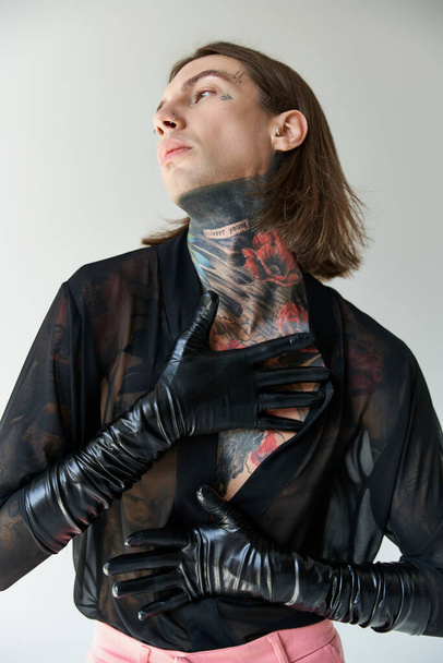 good looking sexy man in transparent shirt and stylish leather gloves looking away, fashion concept - Fotó, kép