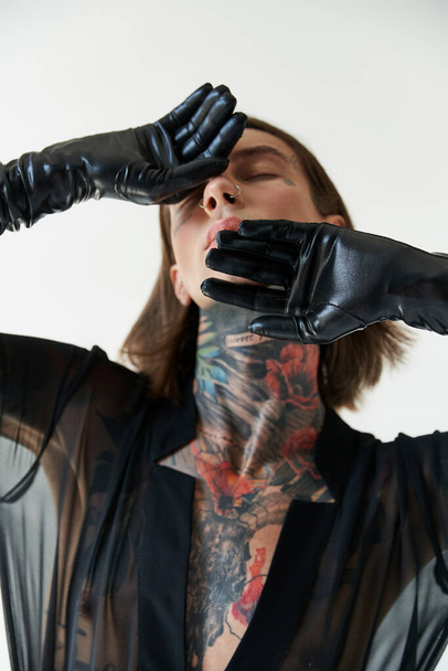 alluring handsome man in stylish attire with hands in leather gloves on face, fashion concept - Fotografie, Obrázek