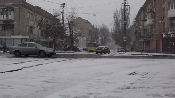 Mykolaiv, Ucrania - 02202021: nevadas en una ciudad del sur - tranvía amarillo con la inscripción "Mykolaiv" pasa a lo largo de la calle de nieve - Imágenes, Vídeo