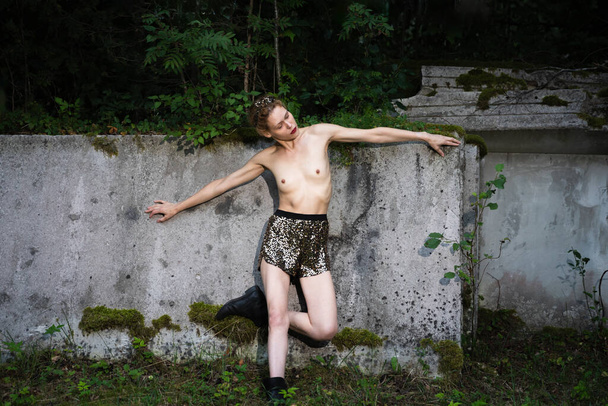 Uma jovem mulher posa topless na floresta entre lajes de concreto. - Foto, Imagem