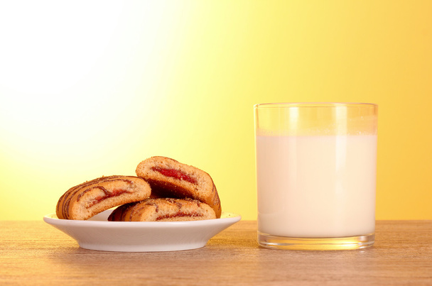 Cookies with milk on yellow background - Foto, afbeelding
