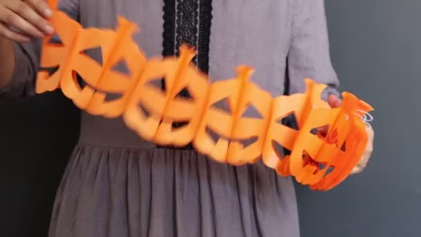 Mujer sosteniendo guirnalda de linternas de calabaza de Halloween sobre fondo oscuro. concepto de celebración de Halloween.  - Imágenes, Vídeo