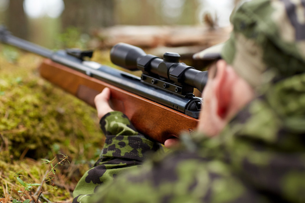 soldier or hunter shooting with gun in forest - Φωτογραφία, εικόνα