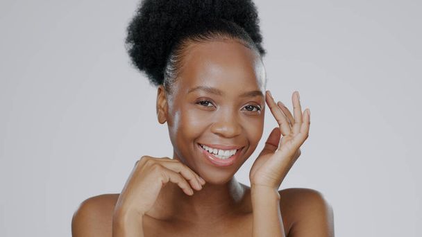 Gesicht, Hautpflege und Hände einer glücklichen schwarzen Frau im Studio isoliert auf grauem Hintergrund. Porträt-, Berührungs- und natürliche Schönheitskosmetik des Modells in der Gesichtsbehandlung des Kurortes für Wellness, Gesundheit oder Ästhetik. - Foto, Bild