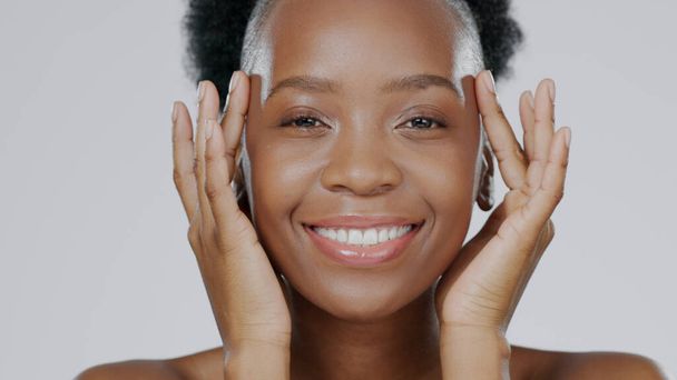 Face touch, skincare and happy black woman in studio isolated on a gray background for dermatology. Portrait, hands and natural beauty cosmetics of model in spa facial treatment, wellness and health. - 写真・画像
