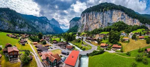 Increíble paisaje de verano del pueblo alpino turístico Lauterbrunnen con la famosa iglesia y la cascada de Staubbach. Ubicación: Lauterbrunnen village, Berner Oberland, Suiza, Europa. - Foto, Imagen
