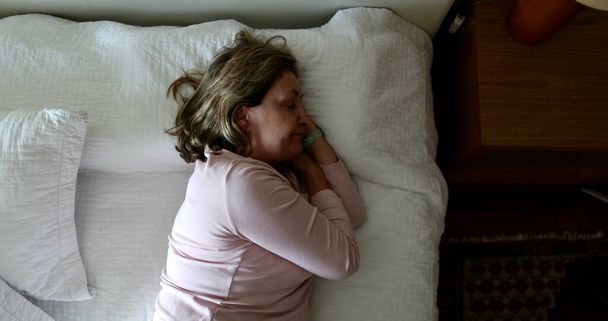 Tired older woman resting taking afternoon nap - Fotó, kép