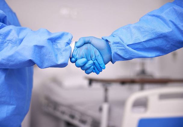 Doktor, ekip ve eldivenli tokalaşma ortaklık, toplantı ya da hastanede tanışma. Klinikte anlaşma ya da anlaşma için çalışan sağlık hemşirelerinin el sıkışması. - Fotoğraf, Görsel