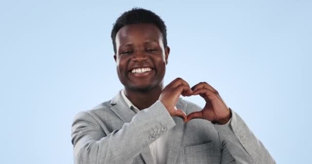 Negocios, manos del corazón o la cara de hombre negro feliz en el estudio para el apoyo, el amor o la caridad sobre fondo azul. Sonrisa, persona africana o emprendedora con forma para el cuidado de la salud, la confianza o la bondad de la empresa. - Metraje, vídeo