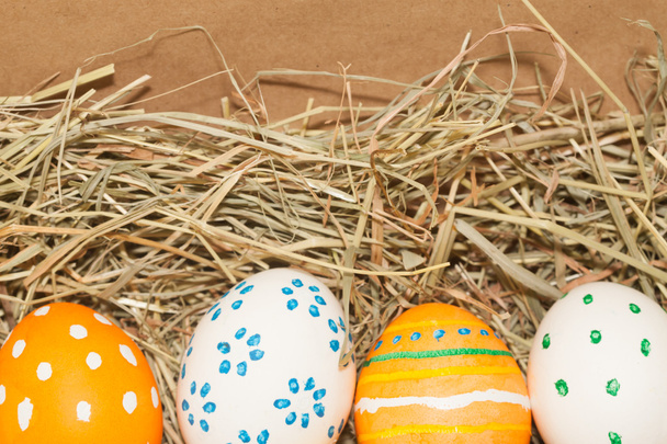 cuatro huevos de Pascua manchados en el heno
 - Foto, imagen