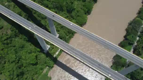 Most nad Rio Cauca i Pacific Highway z niebieskim niebem i drzewami. - Materiał filmowy, wideo