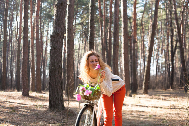 Güneşli parkta bisikletle güzel genç kadın - Fotoğraf, Görsel